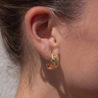 Tapered scroll hoop with clear accents worn on an ear