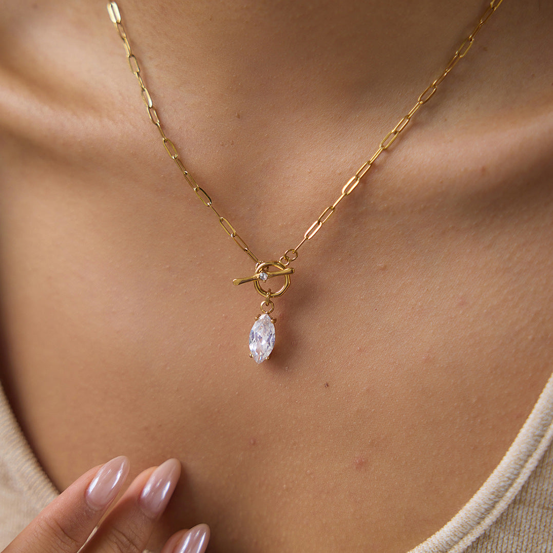 Close view of gold tone toggle and clear marquise drop