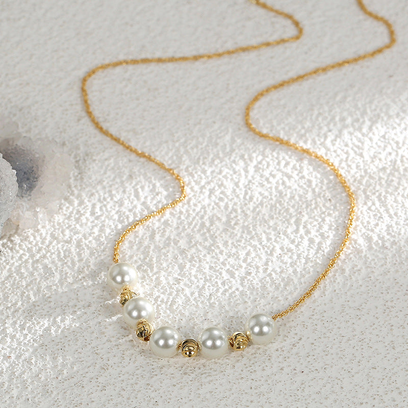 gold plated shell pearl necklace arranged on textured fabric