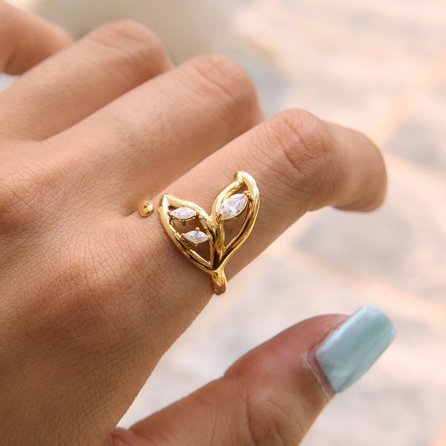 Open leaf ring with clear stones shown on hand