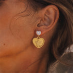 Gold tone angel heart earring shown on the ear
