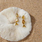 Fish drop earrings front and reverse on textured white surface