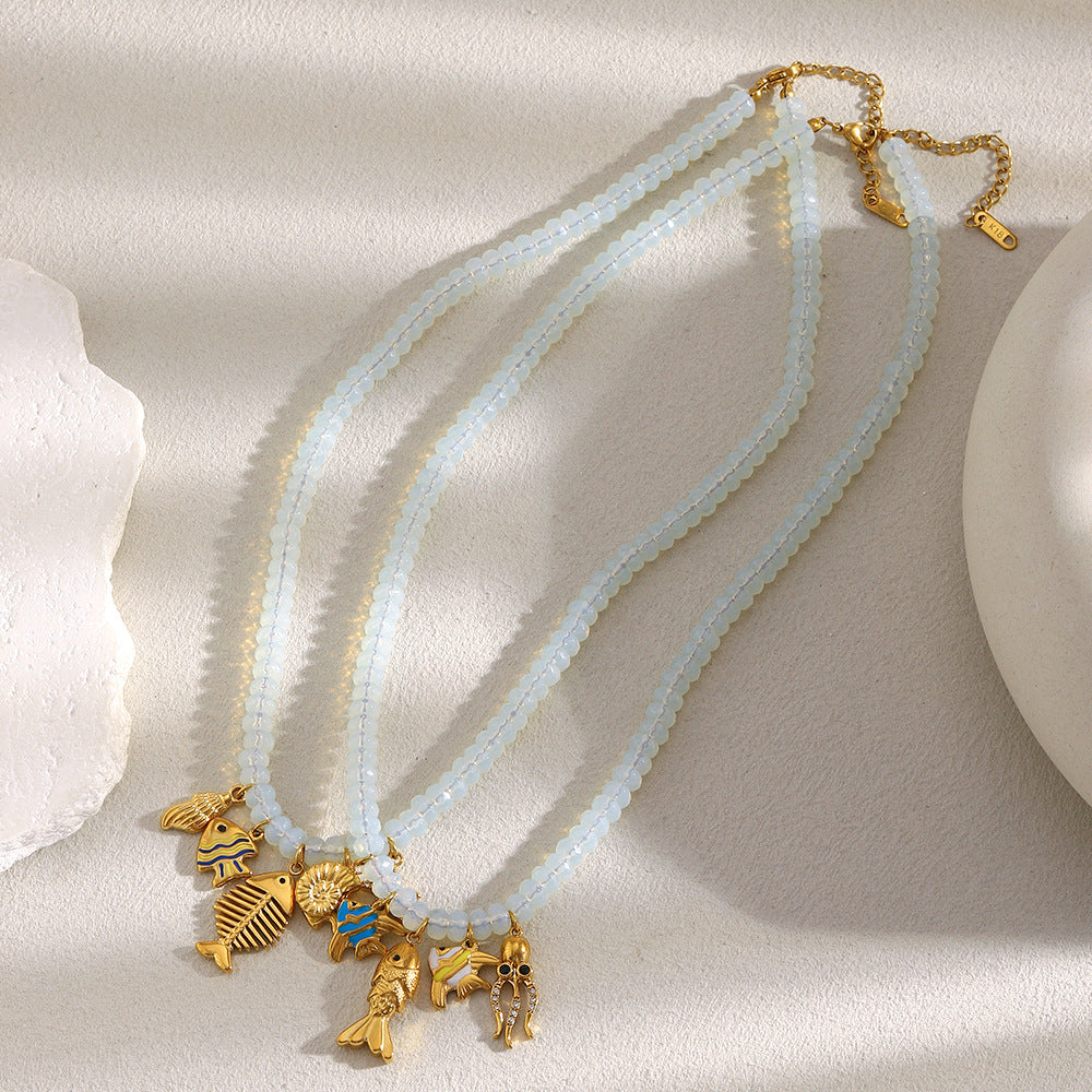 Two sea-life charm necklace designs on a neutral surface