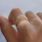 Clear stone chevron ring shown close-up on a finger
