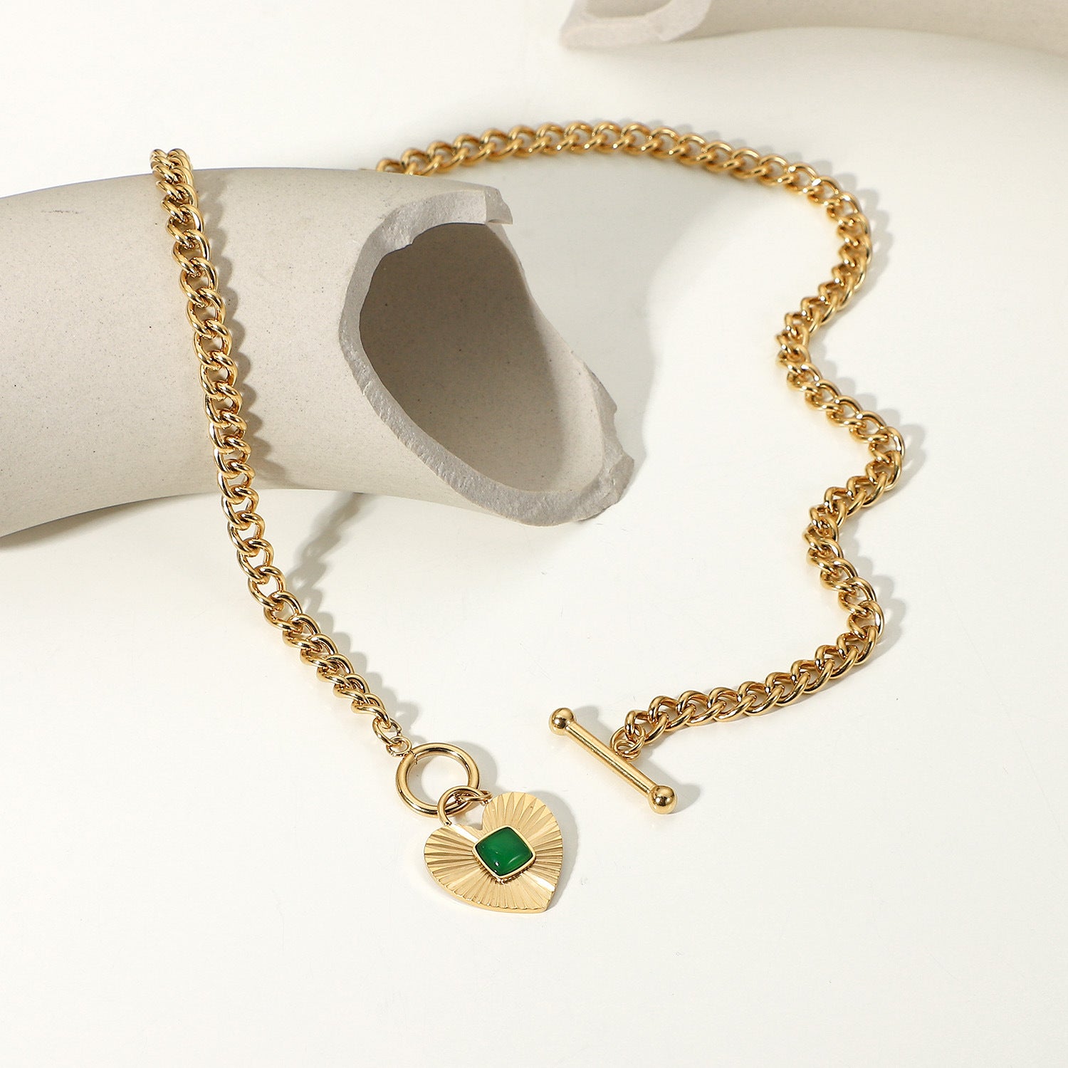 gold plated curb chain necklace with green stone heart pendant and toggle clasp