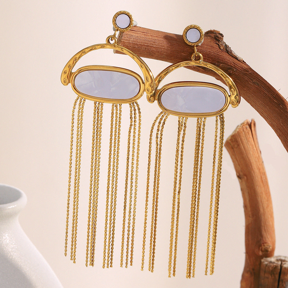 gold plated stainless steel shell chain tassel earrings on natural wood