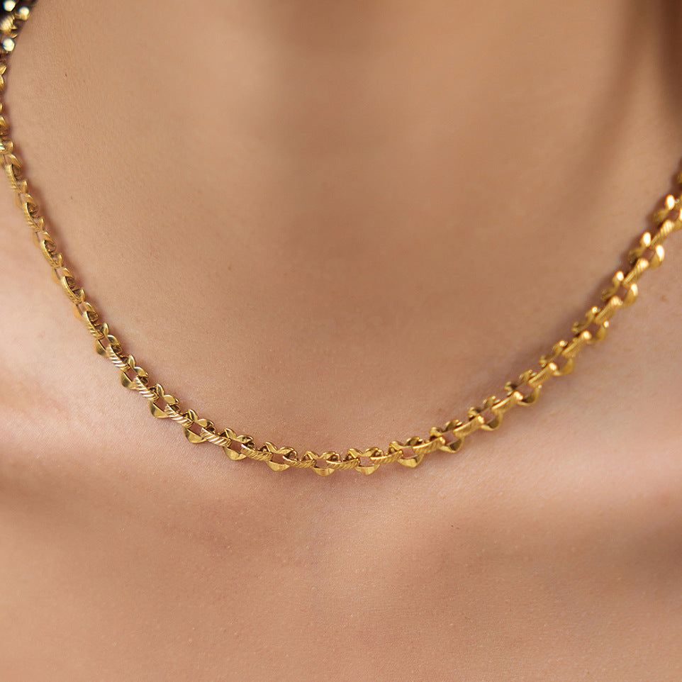 Close view of the repeating gold-tone heart links worn