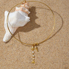 Rigid collar necklace arranged on sand