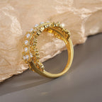 side view of shell pearl filigree ring showing raised clear accents