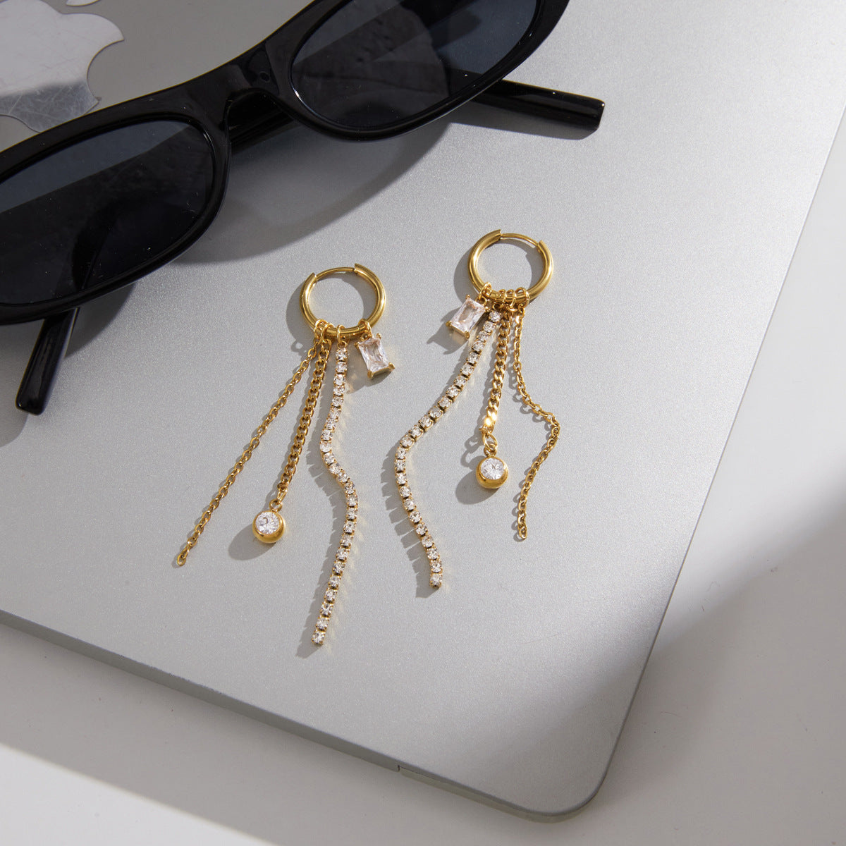 Stone and chain strands arranged beside sunglasses