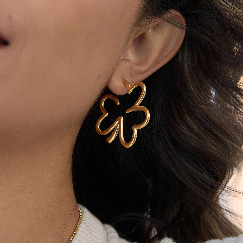gold plated stainless steel open clover statement earring worn on ear