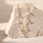 gold plated station necklace with spaced white pearl-style beads on stone