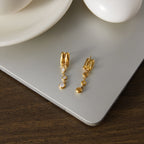 Pair of clear-bezel drop earrings on a display surface