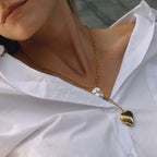 Heart locket Y necklace with white bead drop worn on a model