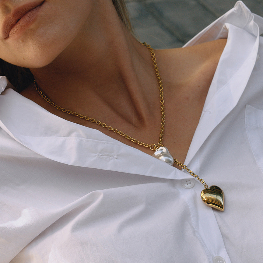 Heart locket Y necklace with white bead drop worn on a model