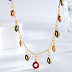 close view of red navy black and blush resin rings on a fine chain