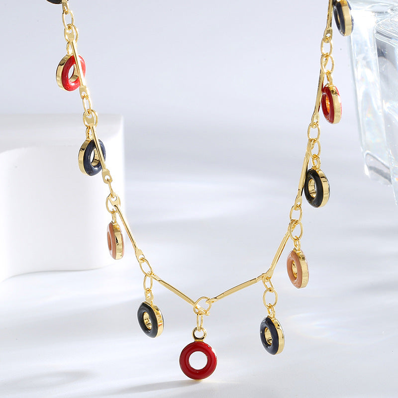 close view of red navy black and blush resin rings on a fine chain