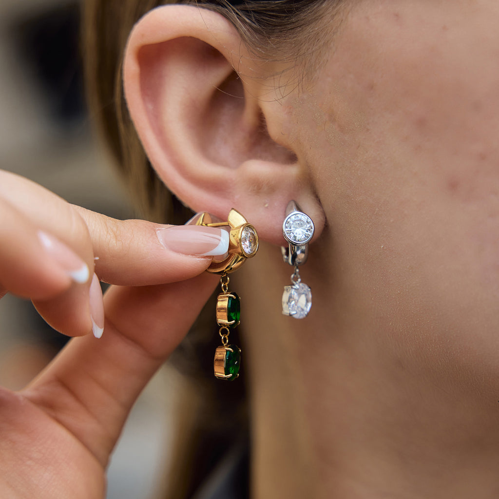 Model showing clear and green asymmetric earrings