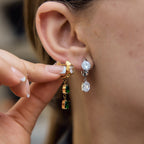 Model showing clear and green asymmetric earrings