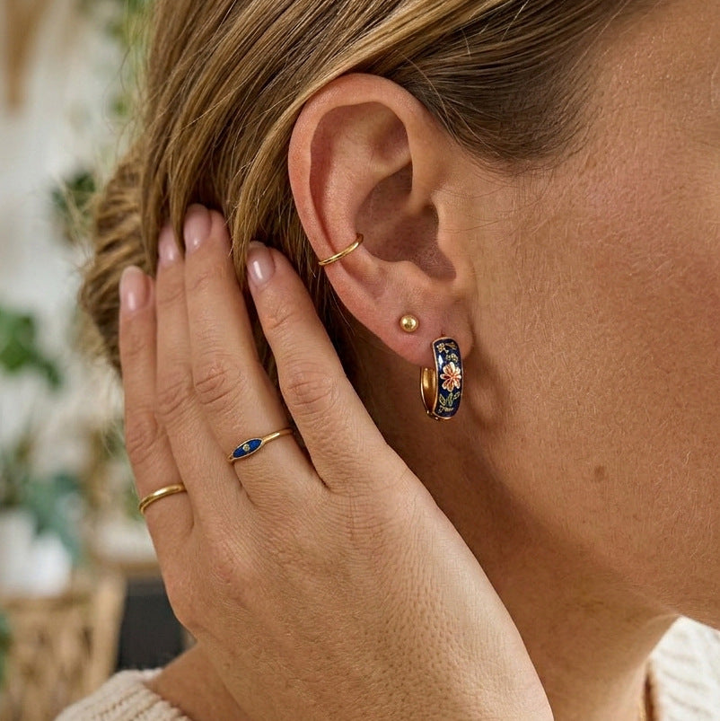 Dark floral hoop earring worn on model