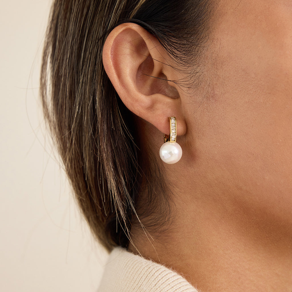 model wearing gold plated stainless steel resin pearl huggies