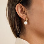 model wearing gold plated stainless steel resin pearl huggies