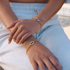 Oval-connector bracelets shown on both wrists