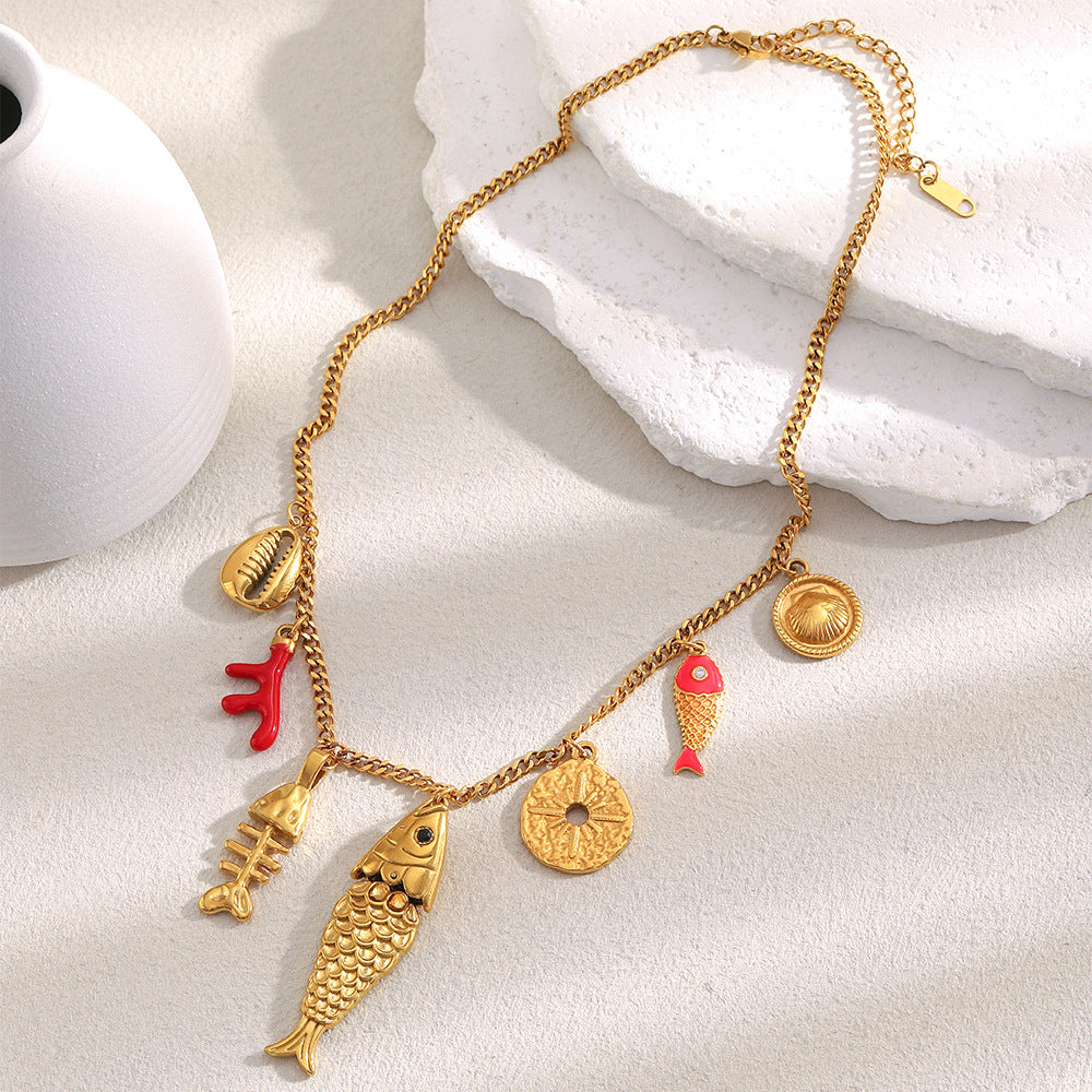 Coastal charm necklace with red fish accent laid flat