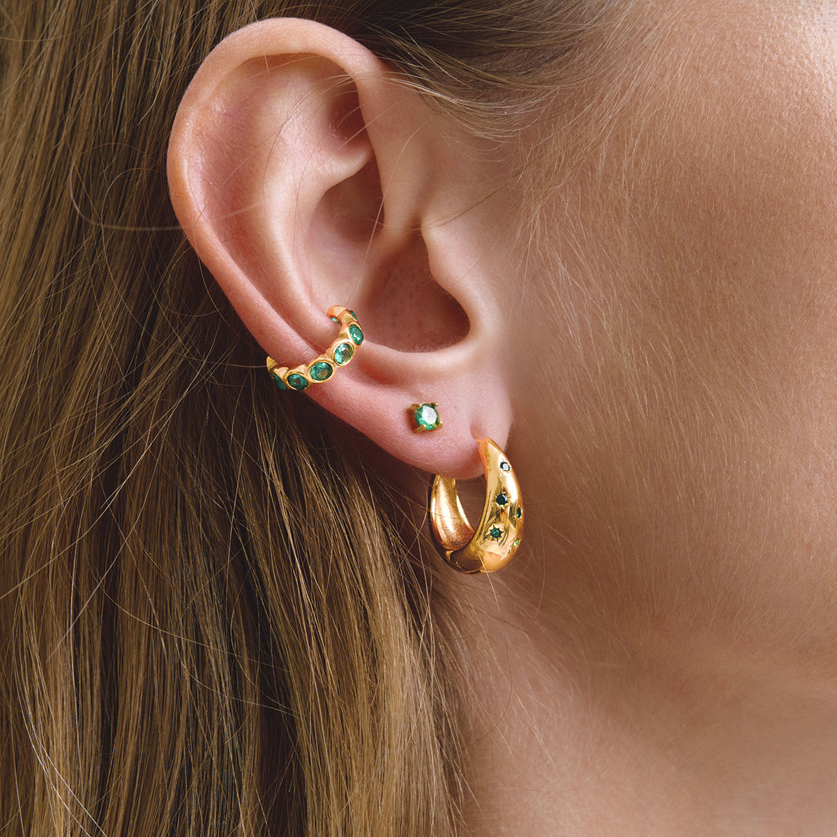 Green drop and hoop earrings styled on the ear