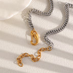 Silver tone Cuban chain beside opened gold tone front clasp