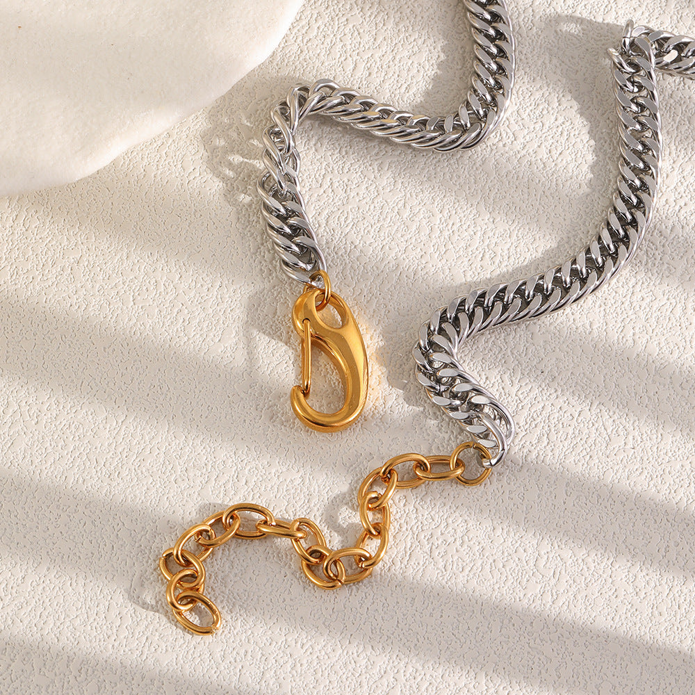 Silver tone Cuban chain beside opened gold tone front clasp