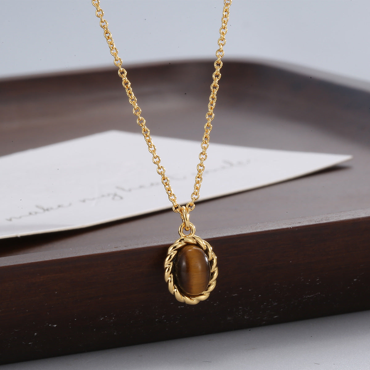 tiger's eye pendant necklace displayed against dark wood