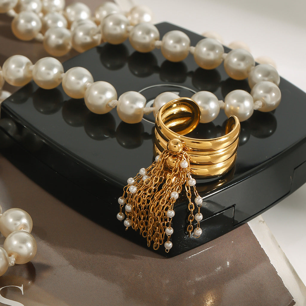 Tassel ring arranged beside pearl-style jewelry