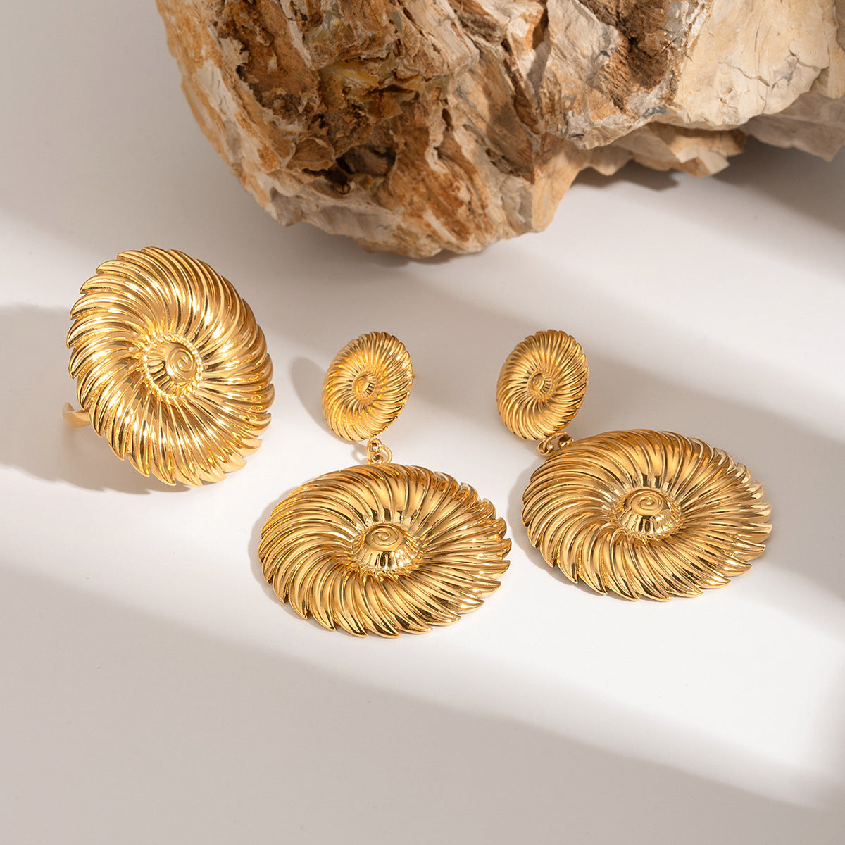 Gold-tone ridged spiral disc earrings with an accompanying ring reference