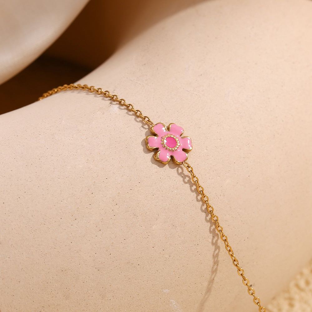 Pink flower chain bracelet displayed on pale stone