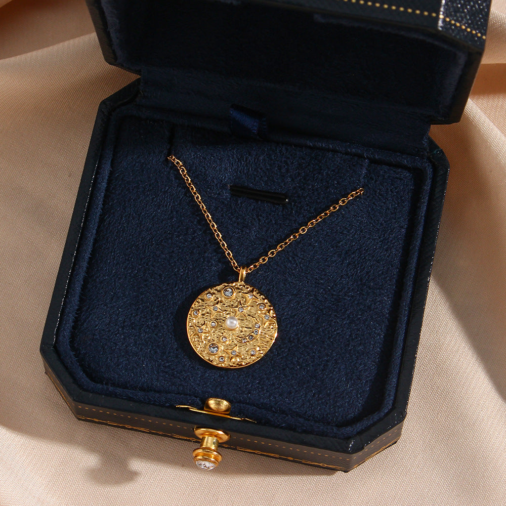 gold plated pearl-style coin pendant necklace inside a dark presentation box