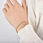 model wearing a slim gold plated Cuban curb chain bracelet