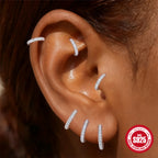 curved silver moissanite flat-back earrings worn in an ear stack