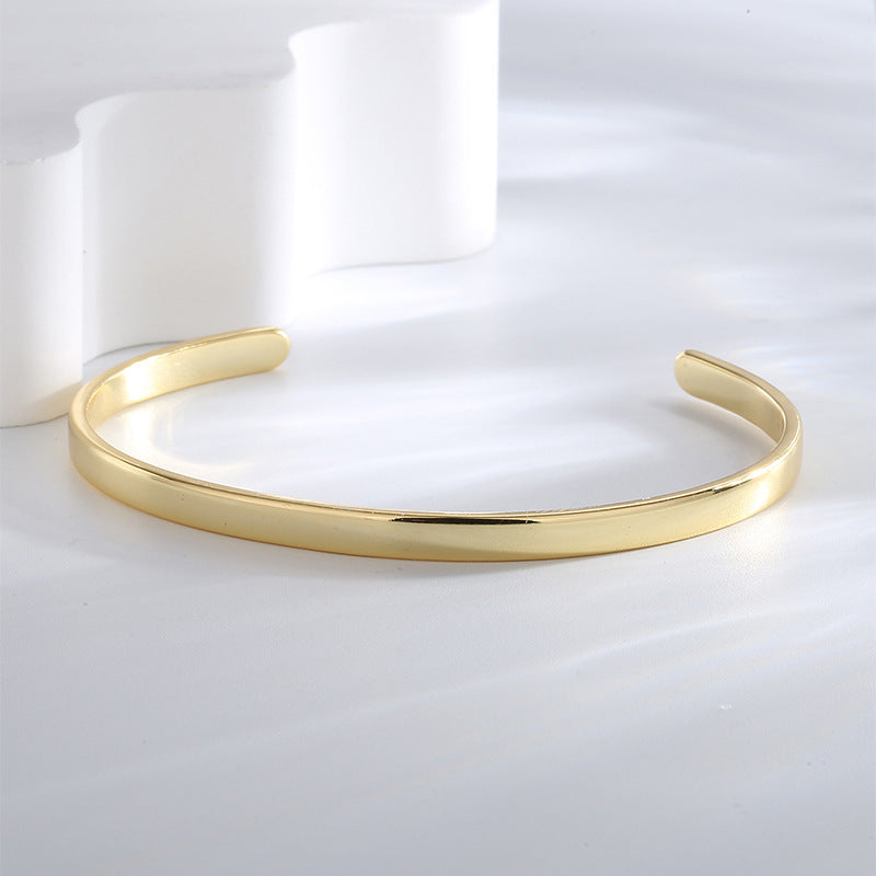 three-quarter view of a polished gold plated zirconia-end bangle