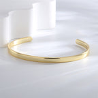 three-quarter view of a polished gold plated zirconia-end bangle