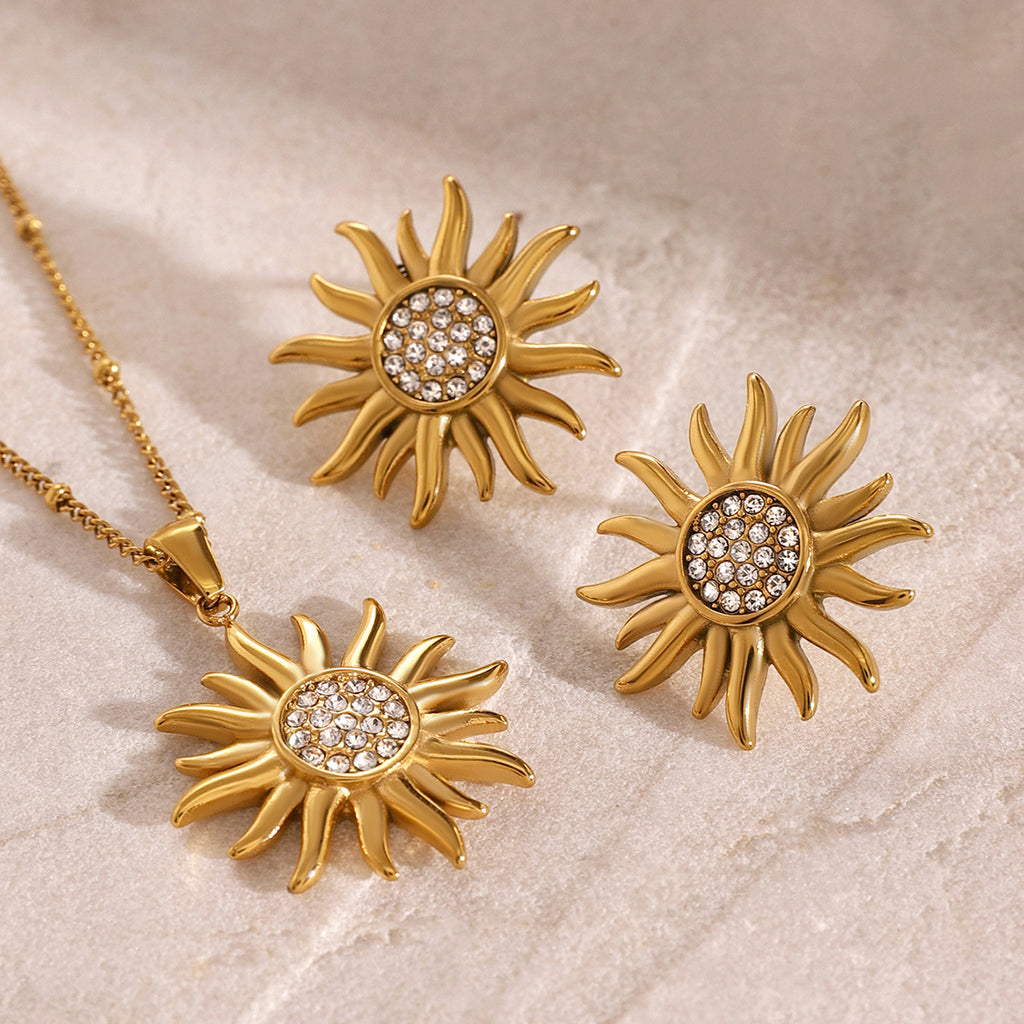 Gold-tone sunburst necklace with clear center accents beside earring references