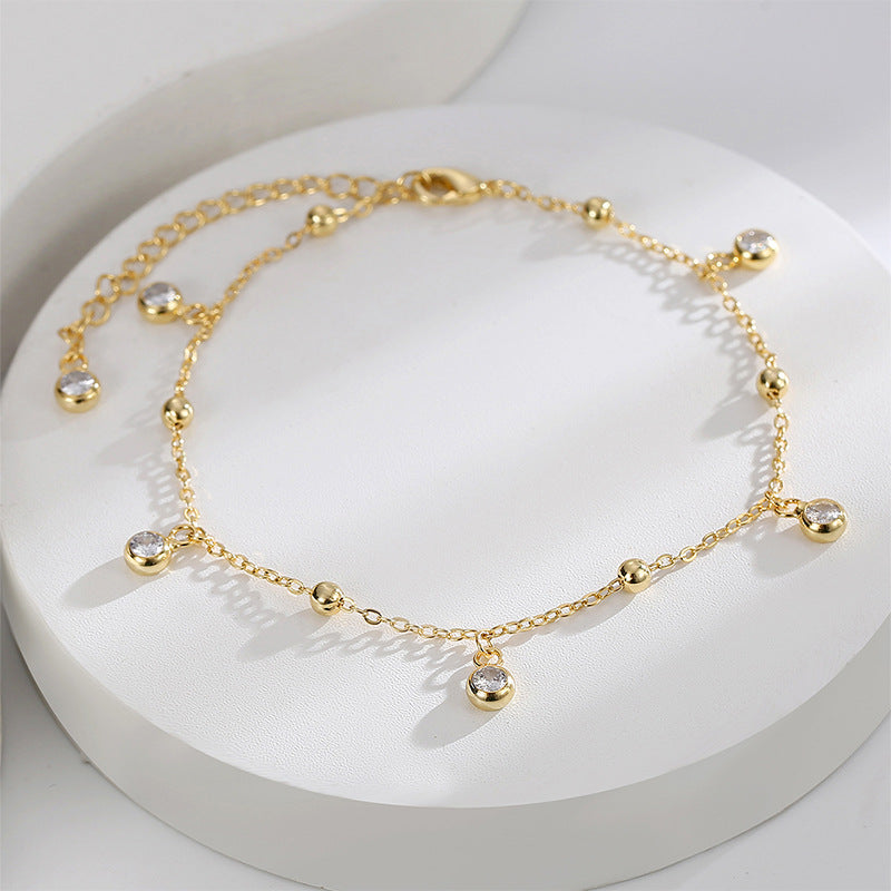 beaded zirconia drop anklet arranged on a white display