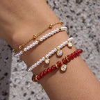 Layered red and white bead bracelets in close-up
