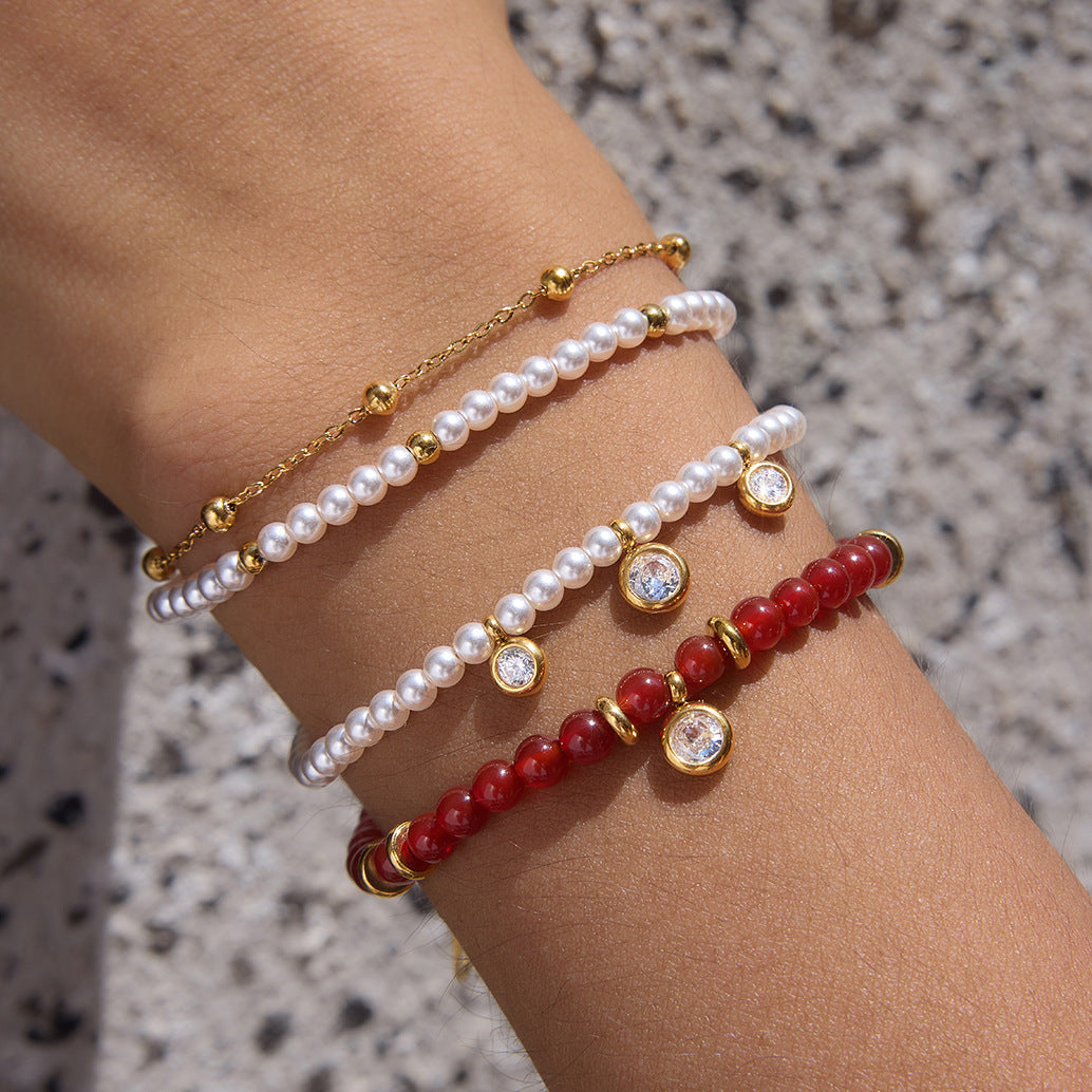Layered red and white bead bracelets in close-up