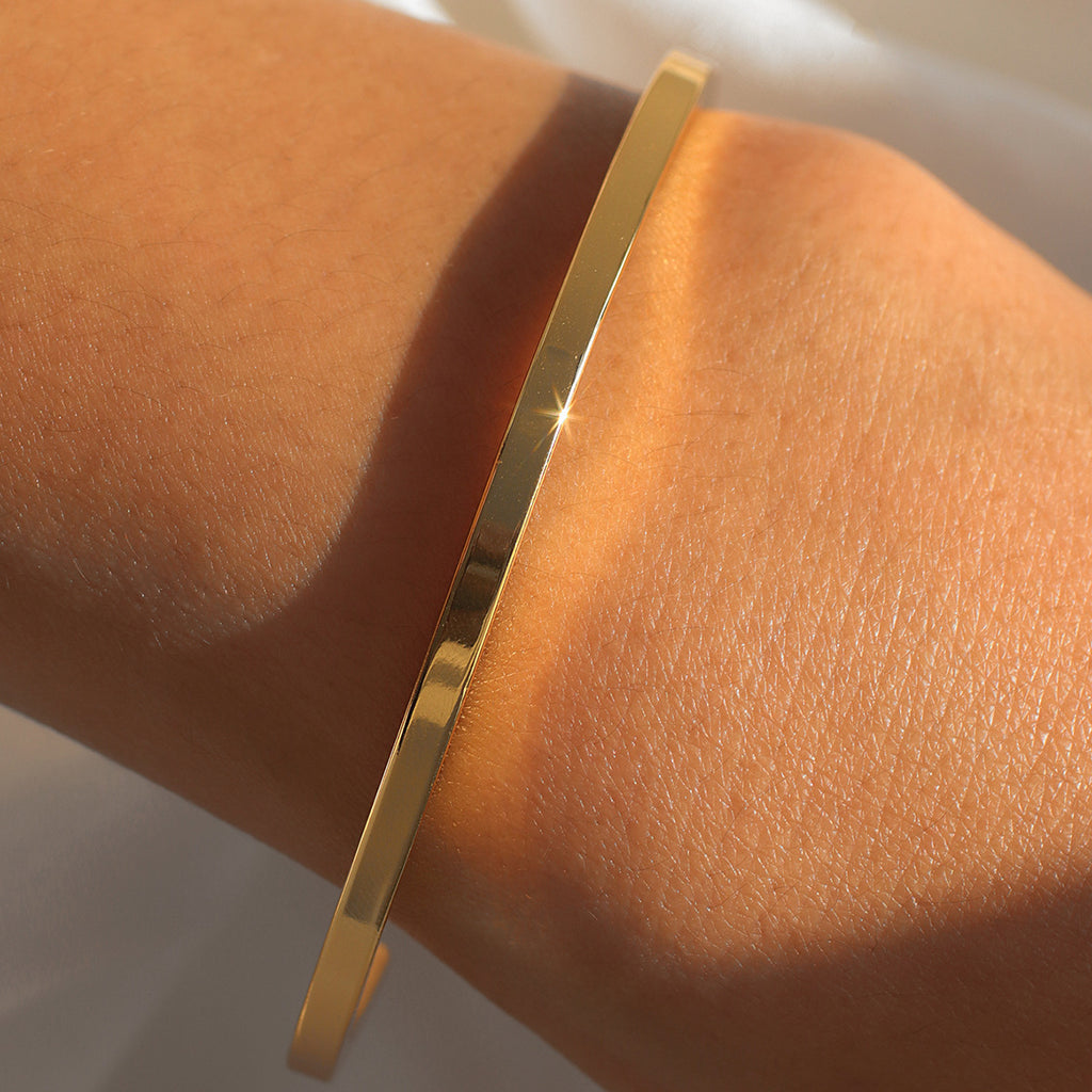wrist view of polished angular gold plated bangle