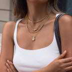 Model wearing paired-stone necklaces in a layered arrangement
