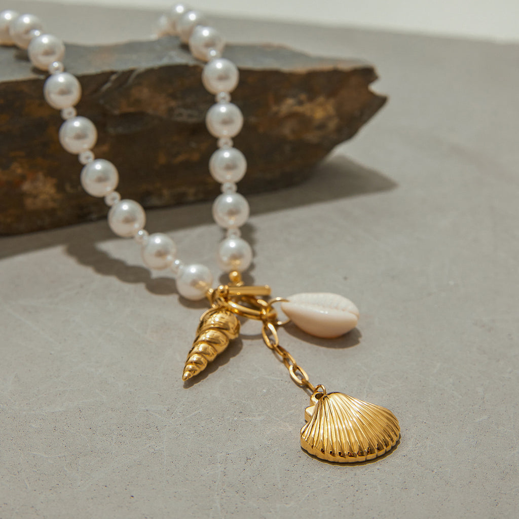 Close-up of the toggle clasp, cowrie-style charm and hanging scallop