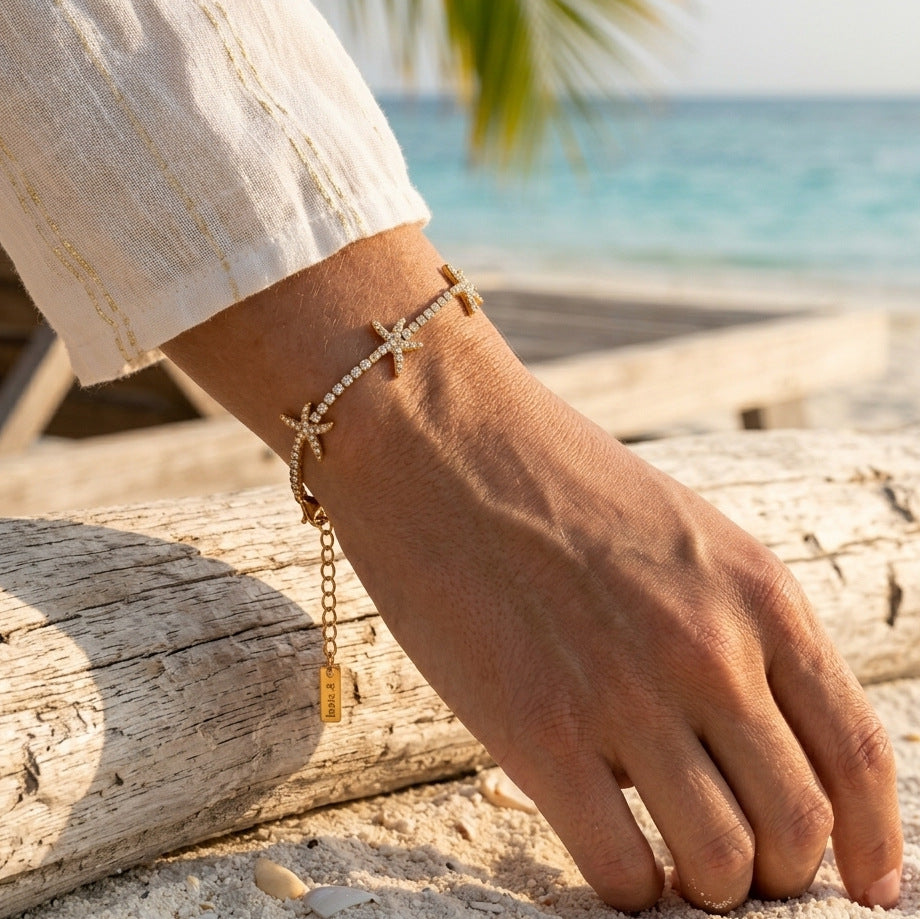 Clear stone starfish bracelet shown worn beside the sea