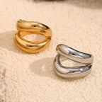 paired gold and silver sculptural rings with open curved bands