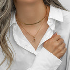 Imitation pearl initial necklace worn with a white shirt